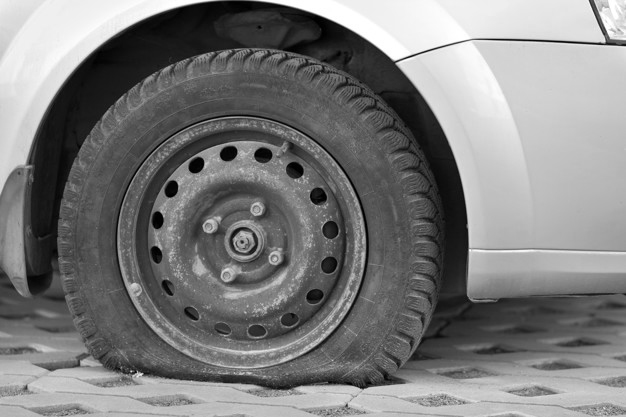flat tyre on pavement - Problems Tyre Punctures can cause on the Road
